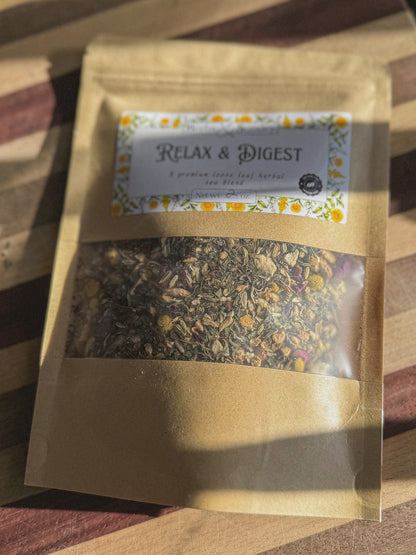 Close view of the Relax and Digest kraft pouch and its floral label on a striped wooden board