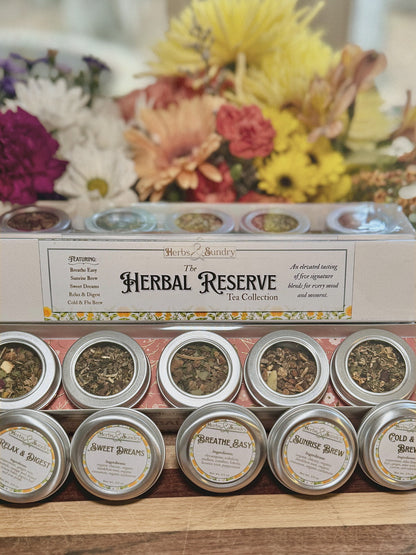 The Herbal Reserve five tin gift set photographed with a bouquet of orange and yellow flowers