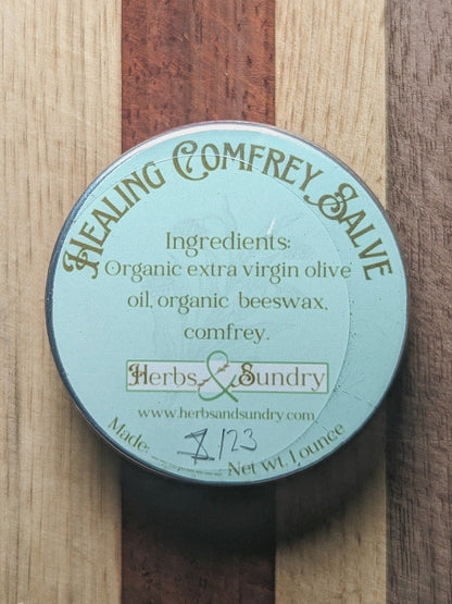 Healing Comfrey Salve tin from above, its pale blue label listing organic olive oil, beeswax and comfrey