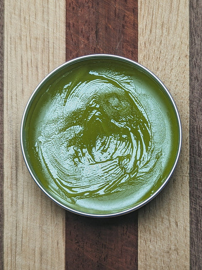 Open tin of Healing Comfrey Salve showing the smooth green balm inside