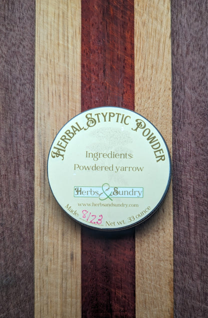 Herbal Styptic Powder tin closed, its pale blue label reading ingredients, powdered yarrow